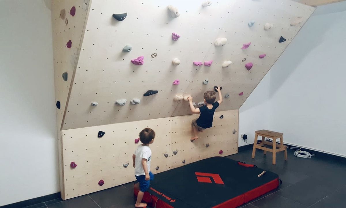 Zwei Kinder an einer Boulderwand mit Überhang