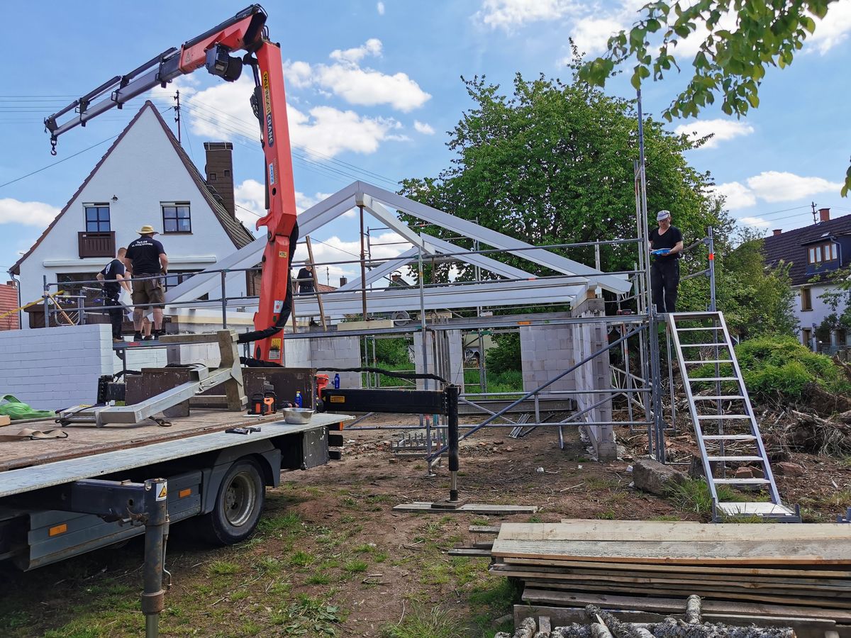 Carport aus Mauerwerk und Holz: der Dachstuhl wird mit dem Kran aufgesetzt