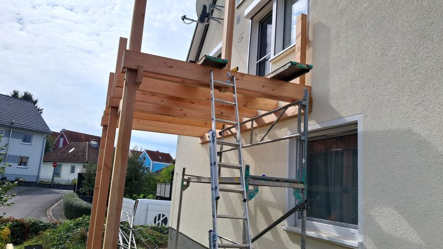 Neues Vordach aus Holz wird an ein bestehendes Wohnhaus angebaut